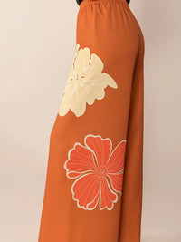 Orange pants with floral patterns on a beige background