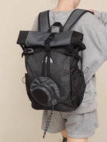 Person wearing a black and gray backpack on a beige background