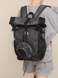 Person wearing a black and gray backpack on a beige background