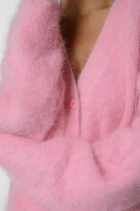 Close-up of a pink textured fabric with a button.