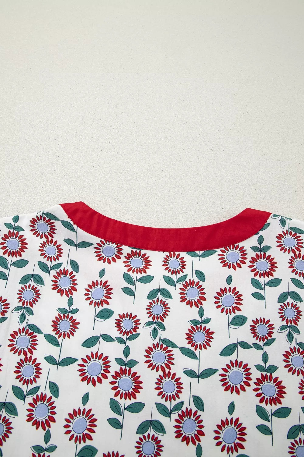 Floral patterned fabric with red neckline on a white background