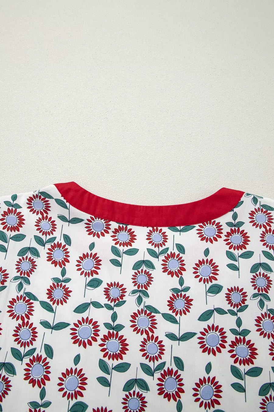 Floral patterned fabric with red neckline on a white background