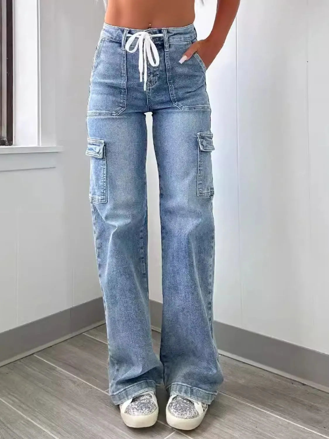 Person wearing light blue cargo jeans with a white background