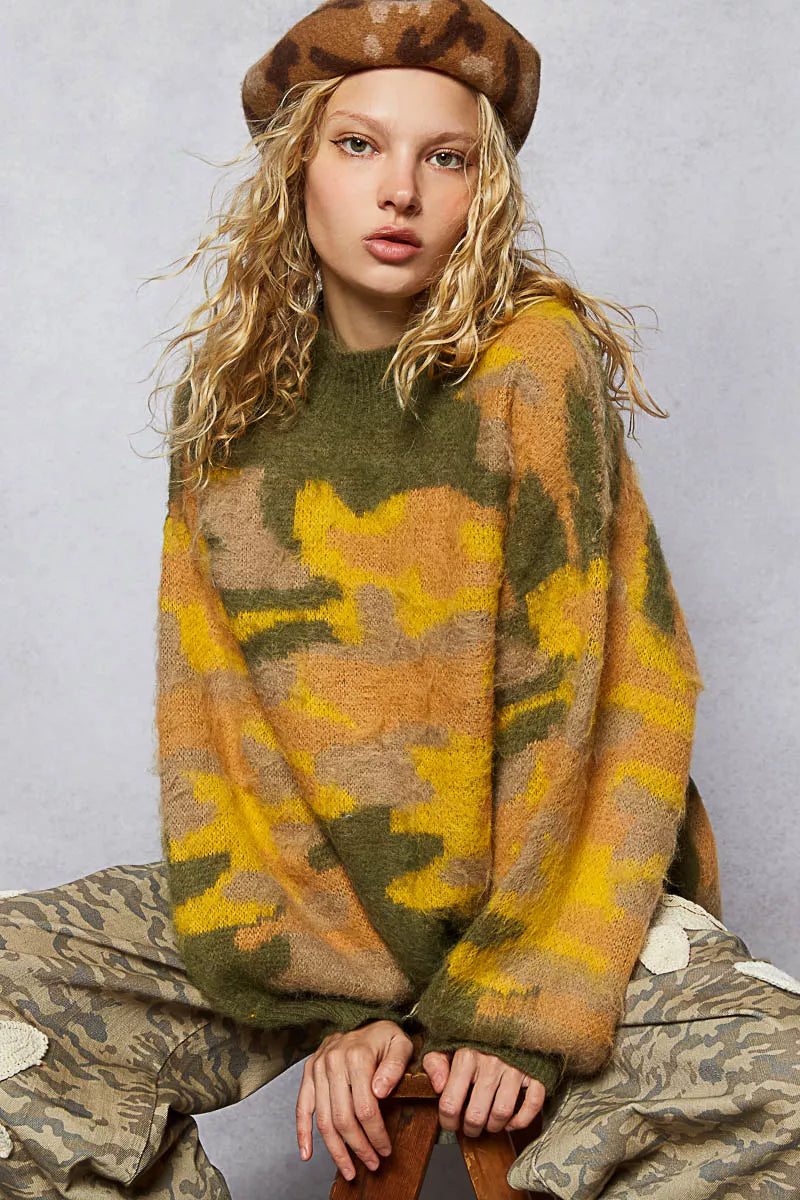 Person wearing a camouflage sweater and beret against a plain background
