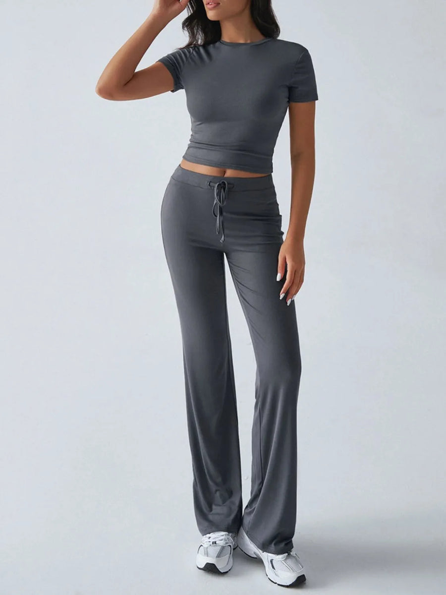 Woman wearing a gray athletic outfit on a white background