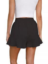 Black shorts worn by a person on a white background
