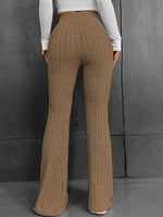 Brown ribbed wide-leg pants worn by a person against a gray background
