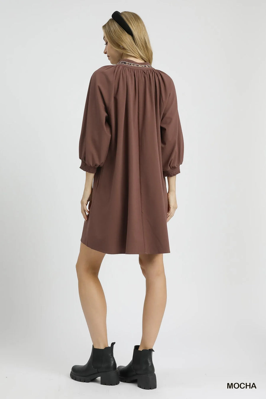 Woman wearing a brown dress on a white background