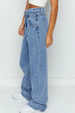 Person wearing light blue jeans on a white background