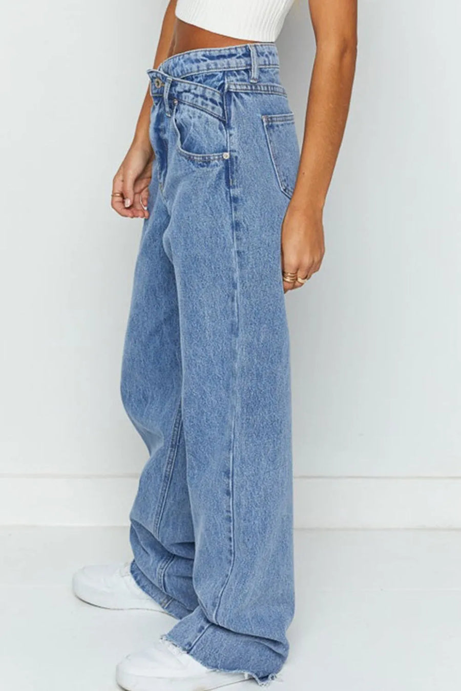 Person wearing light blue jeans on a white background