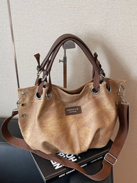 Brown handbag with leather straps on a surface