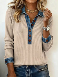 Woman wearing a beige ribbed sweater with denim collar and cuffs on a plain background