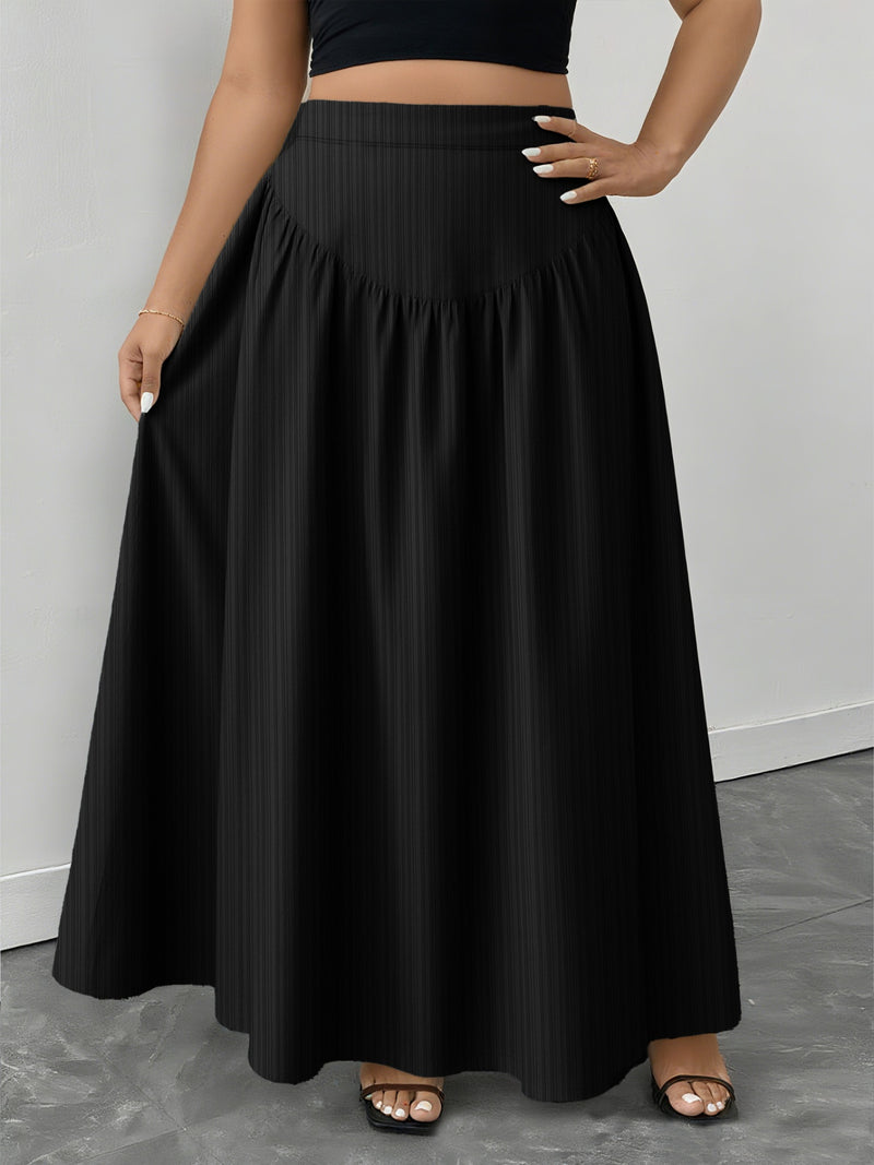 Person wearing a black skirt on a gray floor with a white wall background