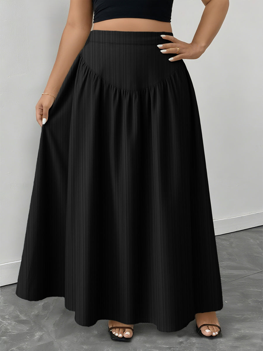 Person wearing a black skirt on a gray floor with a white wall background