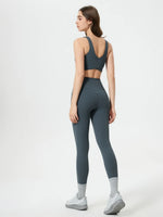 Woman wearing a gray athletic outfit on a white background