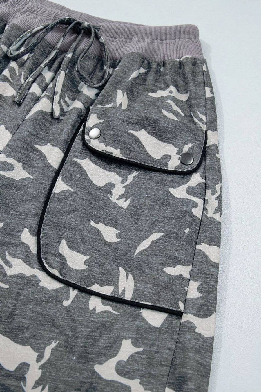 Gray camouflage pants with a pocket on a light gray background