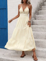 Woman wearing a yellow dress standing on stone steps with a blue door in the background