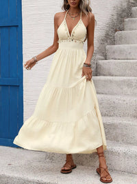 Woman wearing a yellow dress standing on stone steps with a blue door in the background