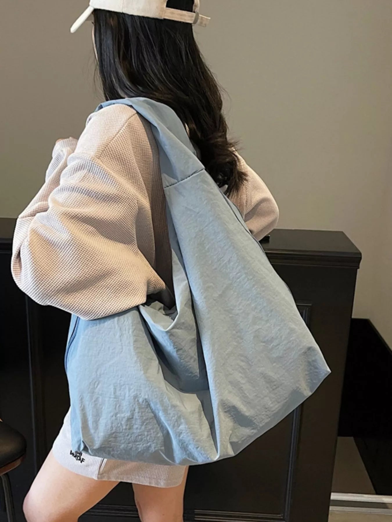 Person wearing a light blue backpack in an indoor setting