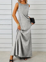 Woman wearing a gray sleeveless dress against a wooden background