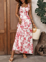 Woman wearing a white dress with red floral pattern, standing outdoors.