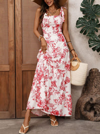 Woman wearing a white dress with red floral pattern, standing outdoors.