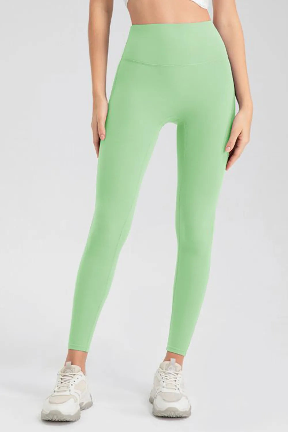 Green leggings worn by a person on a white background