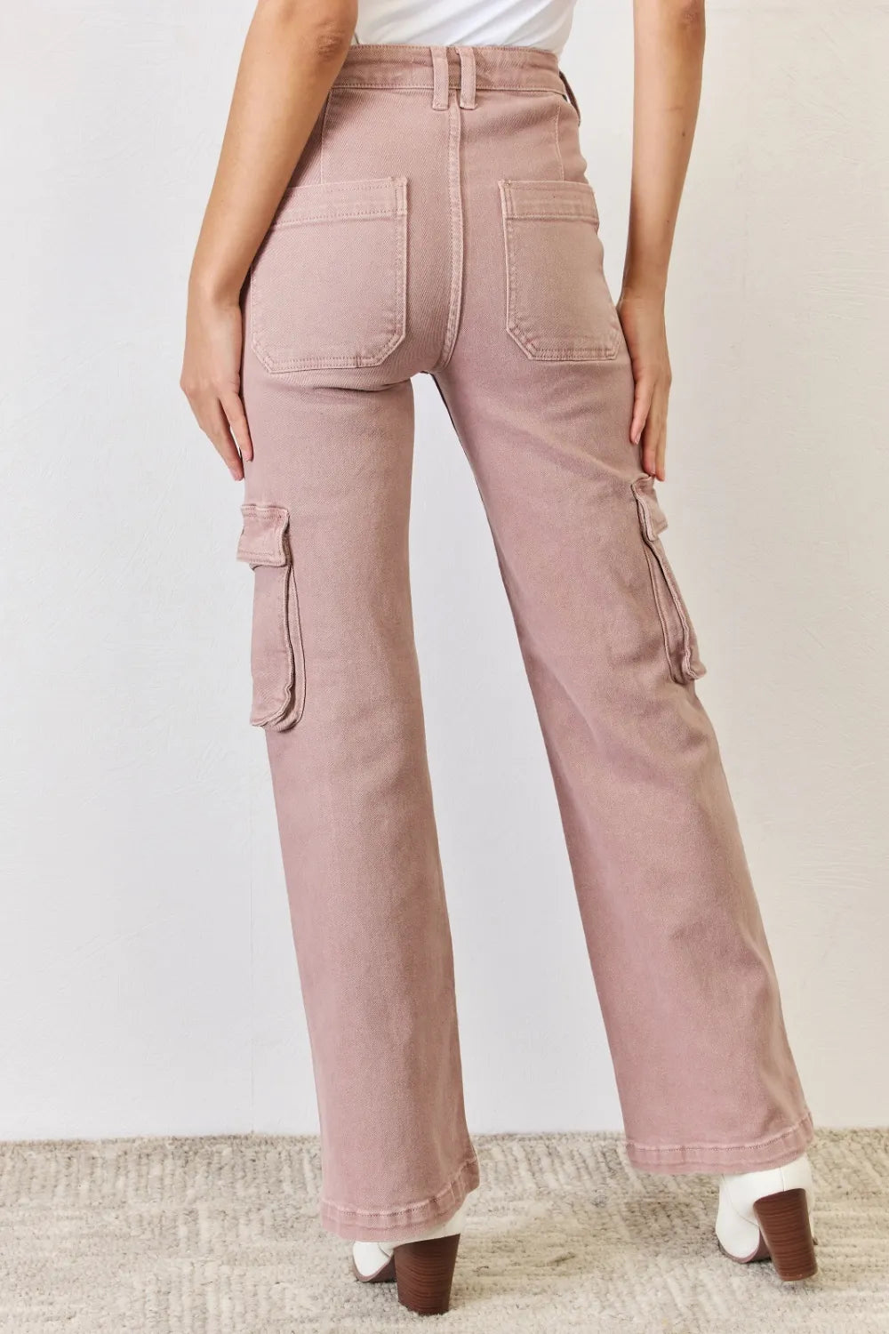 Pink cargo pants worn by a person on a plain background