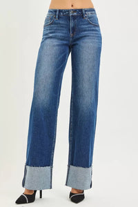 Blue jeans with cuffed hems on a white background
