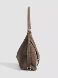 Brown leather handbag on a light gray background