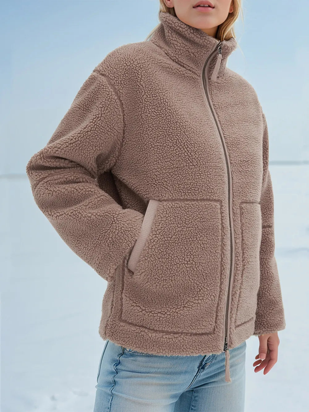 Person wearing a brown fleece jacket with a snowy background
