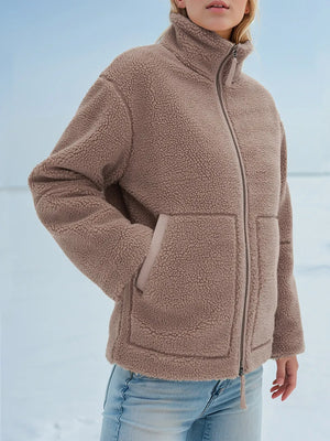 Person wearing a brown fleece jacket with a snowy background