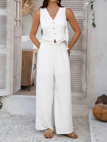 Woman wearing a white sleeveless top and wide-leg pants in a bright outdoor setting.