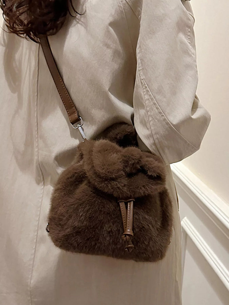 Brown fur bag worn over shoulder against a neutral background