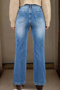 Person wearing blue jeans from behind with a neutral background
