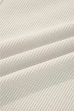 Close-up of textured beige fabric with a waffle pattern