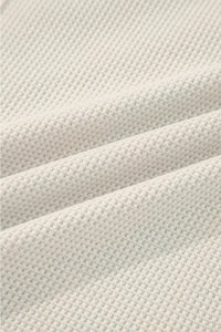Close-up of textured beige fabric with a waffle pattern