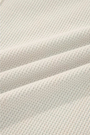 Close-up of textured beige fabric with a waffle pattern
