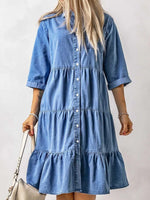 Woman wearing a blue denim dress against a plain background