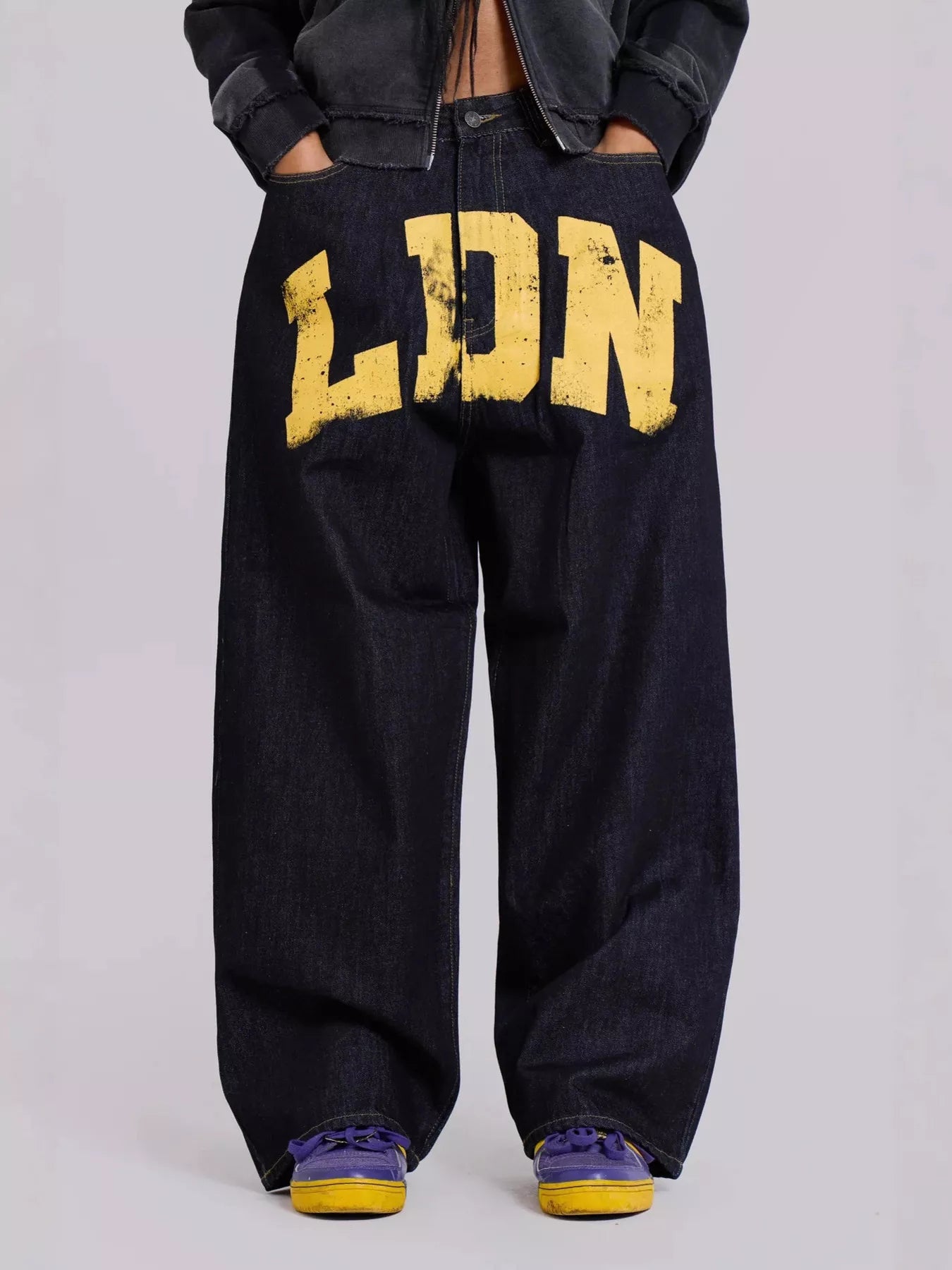 Black pants with 'LDN' printed in yellow on a light gray background