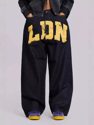 Black pants with 'LDN' printed in yellow on a light gray background