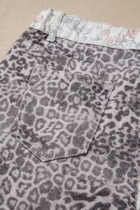 Leopard print denim shorts with floral lining on a beige background