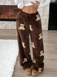 Brown fuzzy pants with teddy bear patterns worn by a person in a home setting.