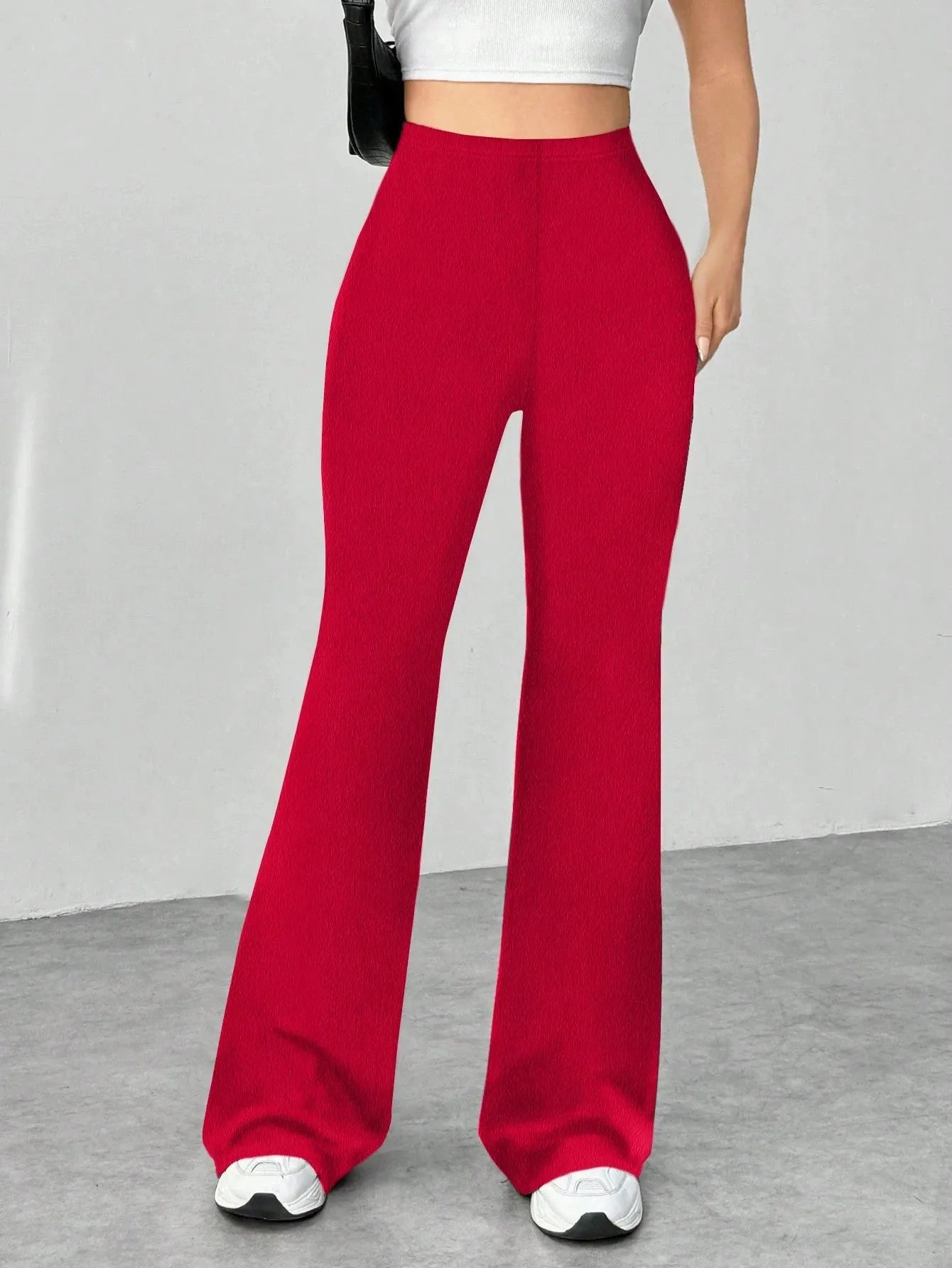 Red wide-leg pants worn by a person on a gray floor with a white wall background