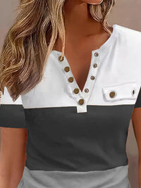 Two-tone black and white top with button details on a neutral background