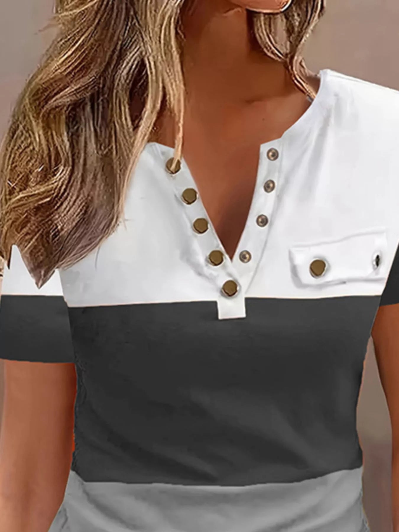 Two-tone black and white top with button details on a neutral background