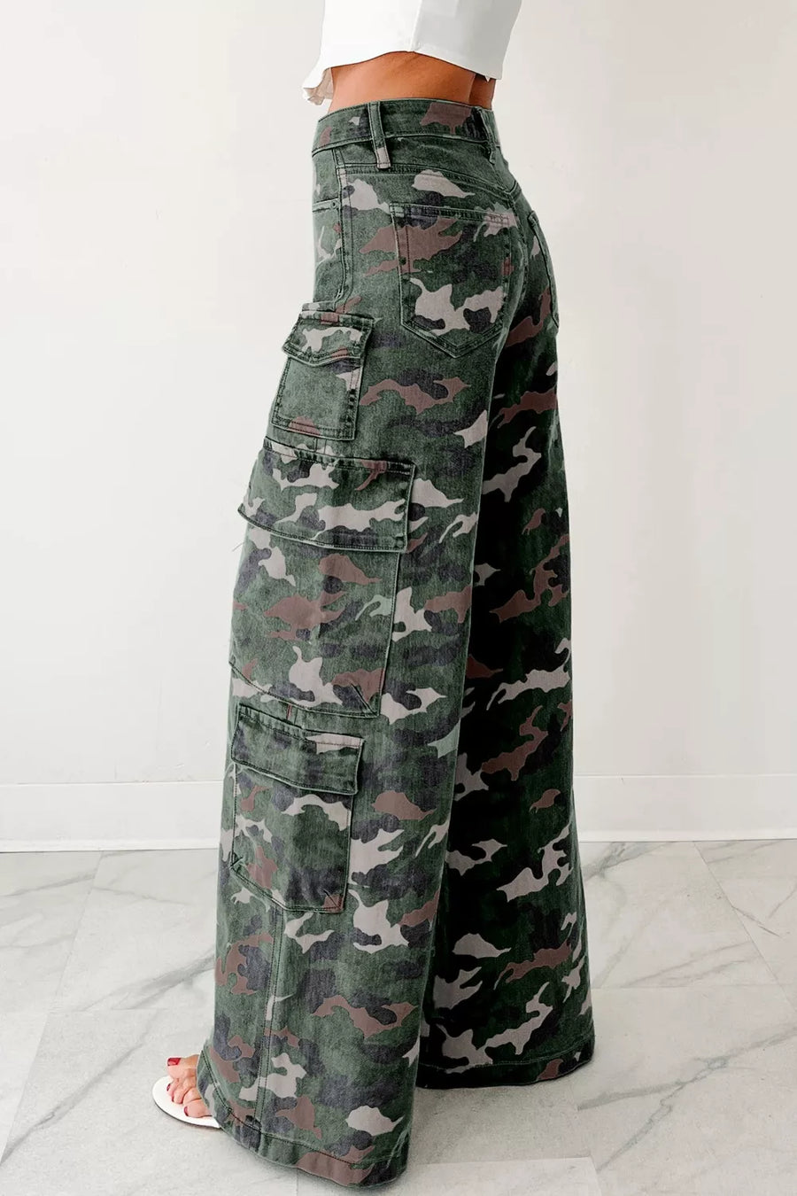 Camouflage cargo pants worn by a person on a white background