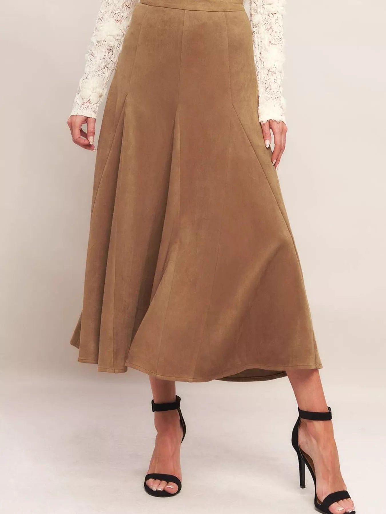 Brown suede skirt worn by a person on a plain background