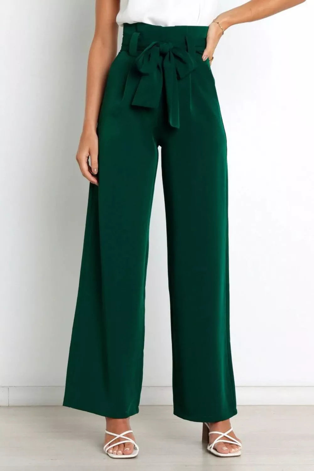 Green wide-leg pants with a tie waist worn by a person on a white background