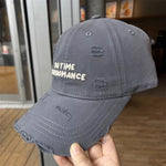 Gray distressed baseball cap with 'No Time For Romance' text held by a hand indoors.